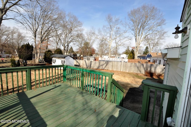 wooden deck featuring a yard and a storage unit