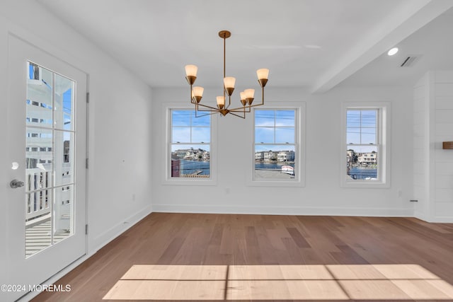 unfurnished dining area with hardwood / wood-style flooring and a chandelier