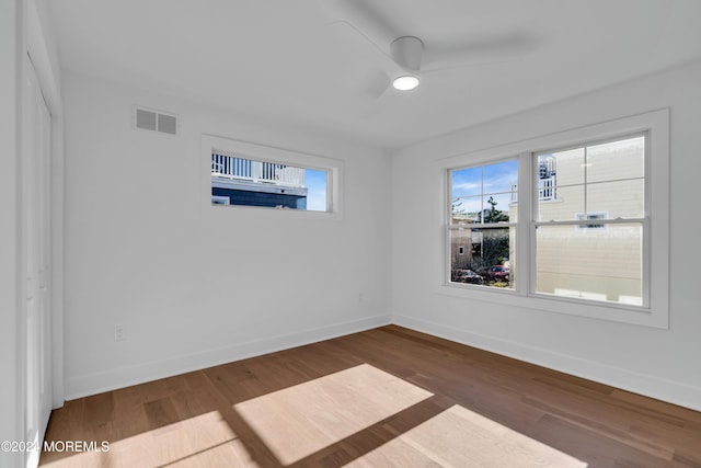 spare room featuring dark wood-type flooring and ceiling fan