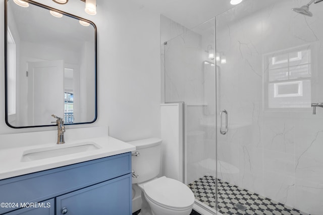 bathroom with vanity, a shower with door, and toilet