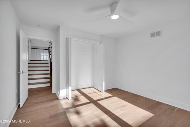 unfurnished bedroom featuring ceiling fan, a closet, and light hardwood / wood-style flooring