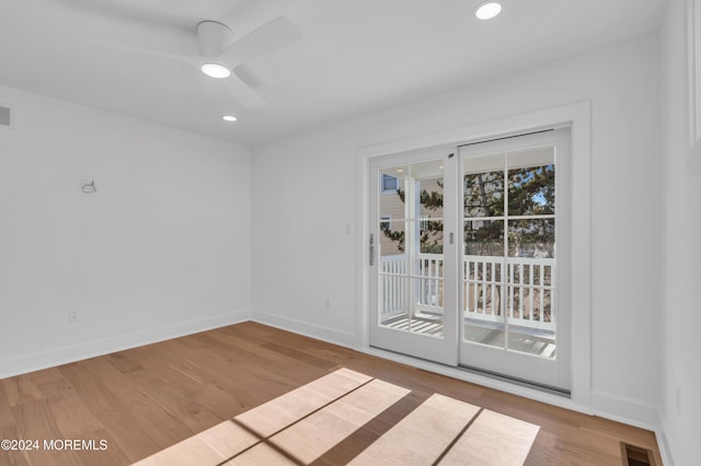 empty room with ceiling fan and light hardwood / wood-style flooring