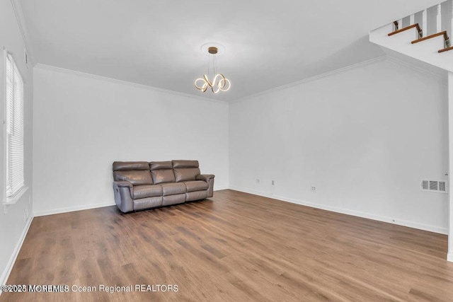 living area featuring crown molding, hardwood / wood-style floors, and a notable chandelier