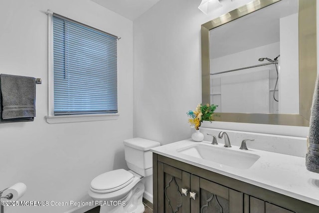 bathroom featuring vanity, a shower, and toilet