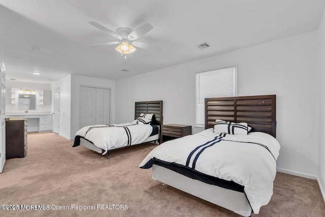 carpeted bedroom with ceiling fan, ensuite bath, and a closet