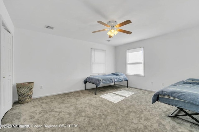 bedroom with light colored carpet, ceiling fan, and a closet