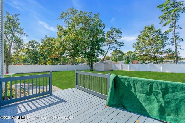 wooden terrace with a yard and a storage unit