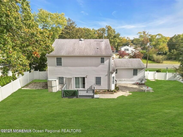 back of property with a patio area and a lawn