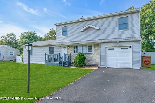 back of property featuring a garage and a lawn