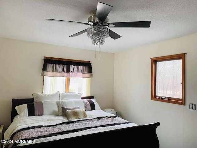 bedroom with ceiling fan and a textured ceiling