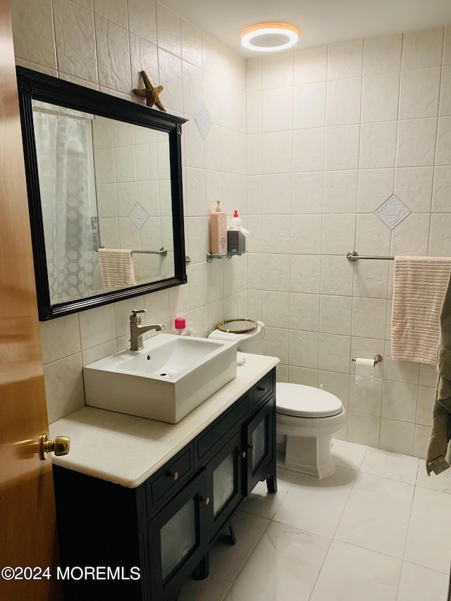 bathroom featuring tile walls, vanity, and toilet