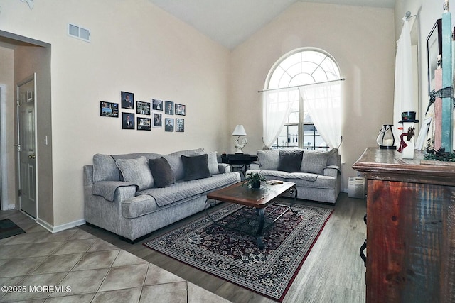 living room with hardwood / wood-style flooring and high vaulted ceiling