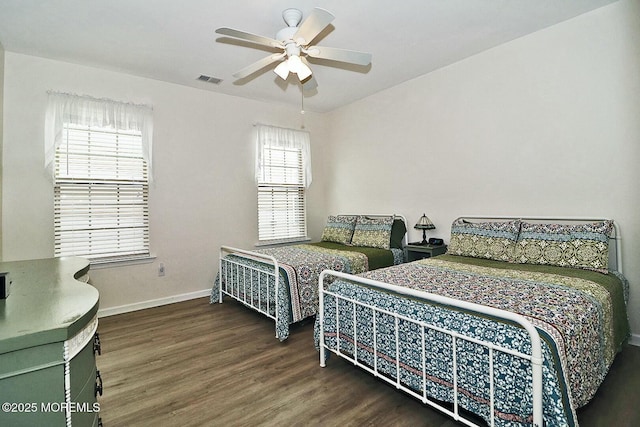 bedroom featuring multiple windows, dark wood-type flooring, and ceiling fan