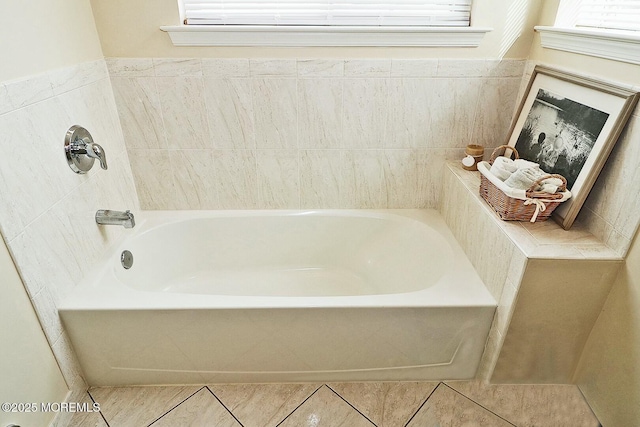 bathroom with tile patterned floors, a healthy amount of sunlight, and a washtub