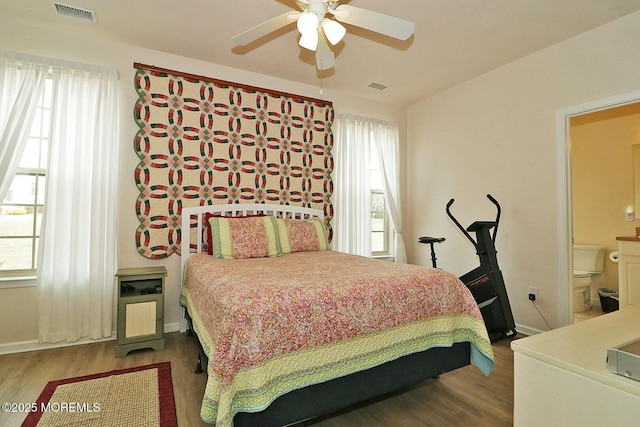 bedroom with hardwood / wood-style flooring and multiple windows