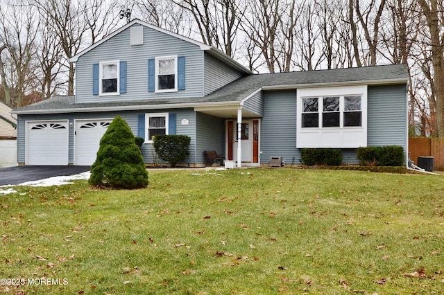 view of front facade featuring a garage, central air condition unit, and a front lawn