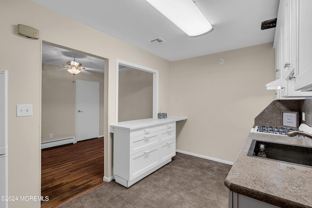 kitchen featuring white cabinetry, a baseboard heating unit, sink, and ceiling fan