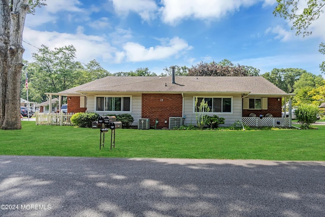 ranch-style house featuring central AC unit and a front yard