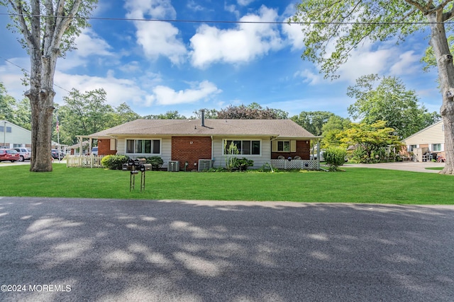 view of front of house featuring central AC unit and a front yard