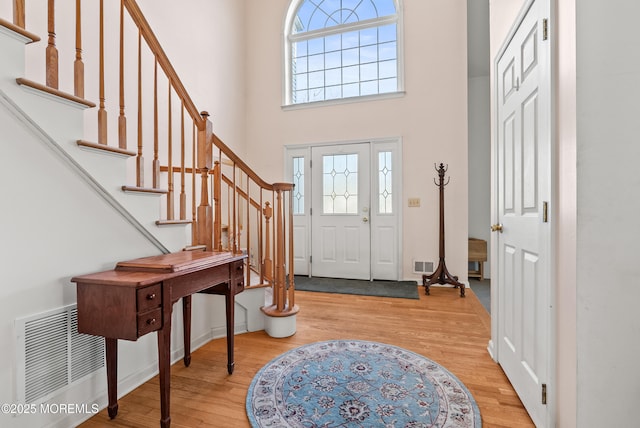 foyer entrance with light hardwood / wood-style floors and a high ceiling