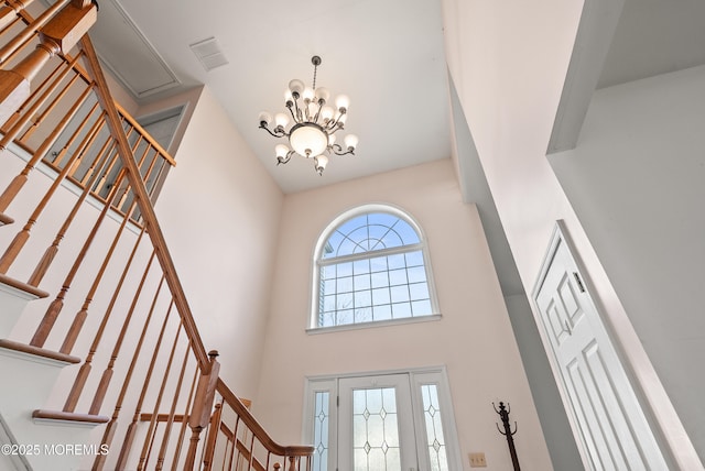 foyer with a towering ceiling and a chandelier