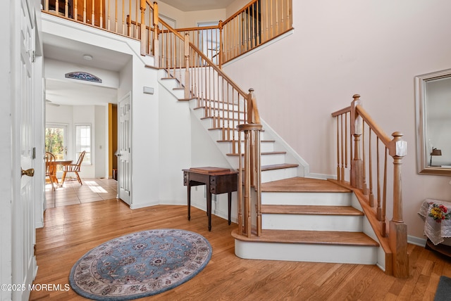 stairway with a high ceiling and wood-type flooring