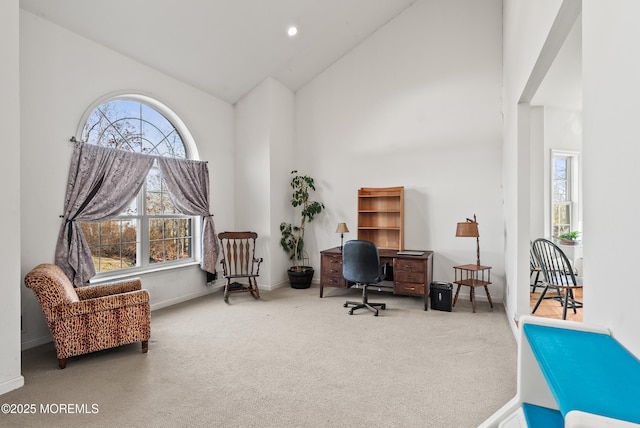 home office with a healthy amount of sunlight, high vaulted ceiling, and carpet flooring