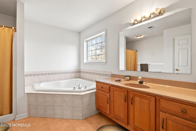 bathroom featuring tiled tub, vanity, and tile patterned floors