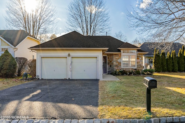 ranch-style house featuring a garage and a front lawn