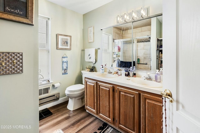 bathroom with hardwood / wood-style flooring, vanity, toilet, and walk in shower