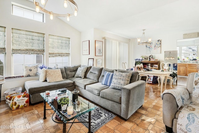 living room featuring light parquet floors, vaulted ceiling, and a chandelier