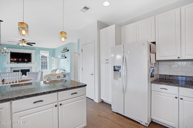 kitchen with white refrigerator with ice dispenser and white cabinets