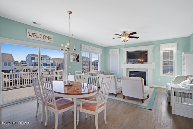 dining room with wood-type flooring and ceiling fan with notable chandelier