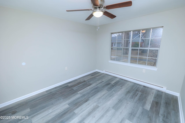 spare room featuring ceiling fan, wood-type flooring, and a baseboard heating unit