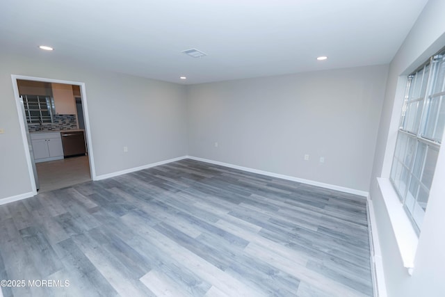 unfurnished room featuring sink and hardwood / wood-style floors