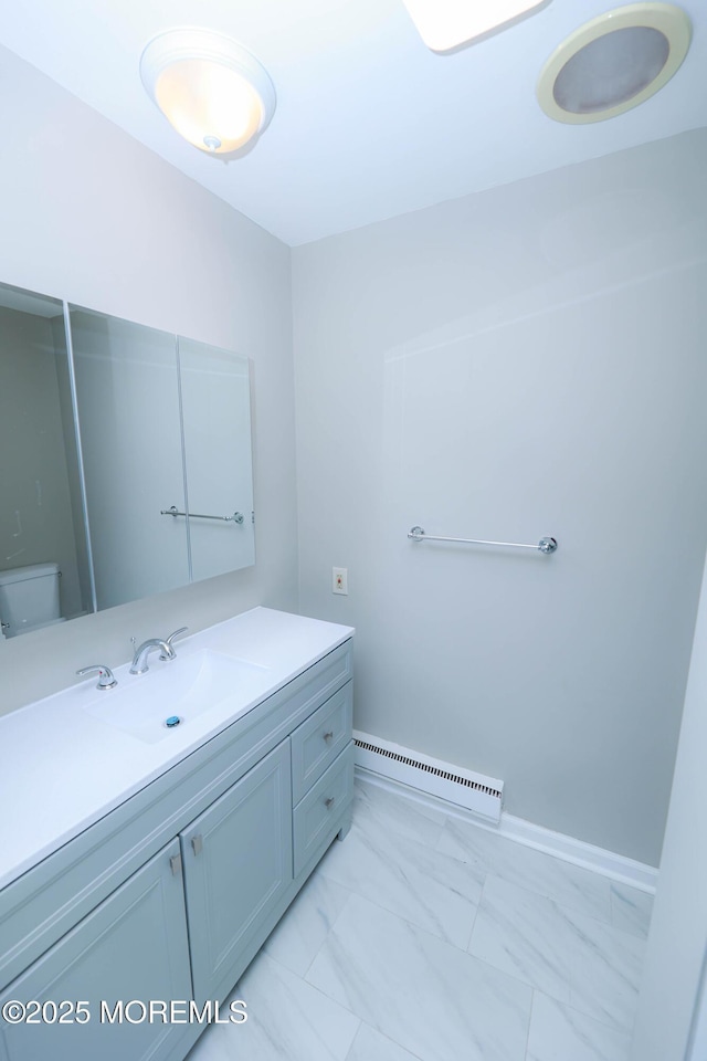 bathroom featuring vanity, a baseboard heating unit, and toilet