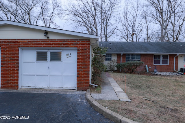 view of front of home with a garage and central air condition unit