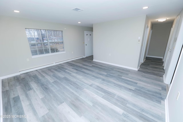 spare room featuring a baseboard radiator and hardwood / wood-style floors