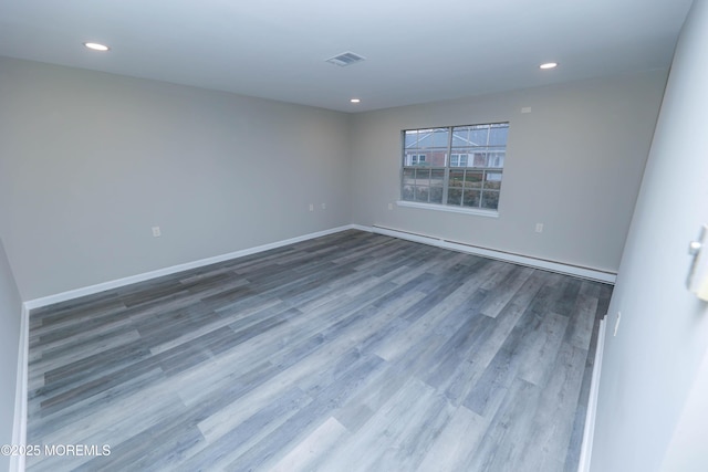 empty room with a baseboard radiator and wood-type flooring