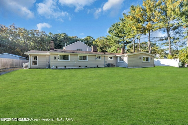 back of property with a lawn and central air condition unit