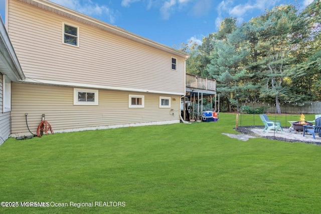 back of house featuring a yard and an outdoor fire pit