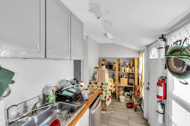 kitchen with dishwasher, vaulted ceiling, sink, and butcher block countertops