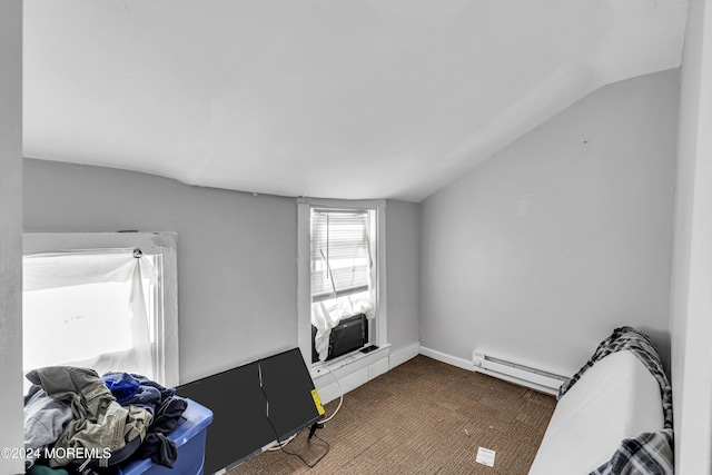 interior space featuring a baseboard radiator, vaulted ceiling, and dark carpet