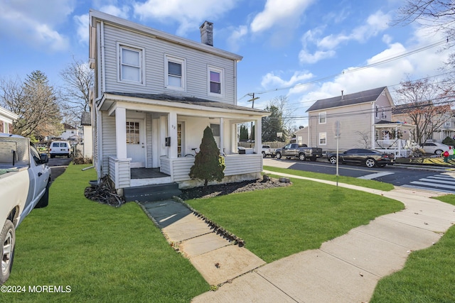 view of front of home featuring covered porch and a front lawn