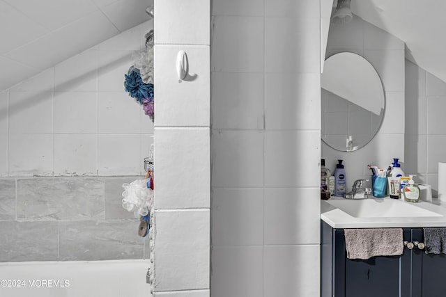 bathroom featuring vanity and tile walls