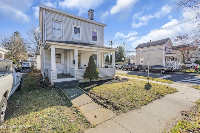 view of front of house with a front yard and covered porch