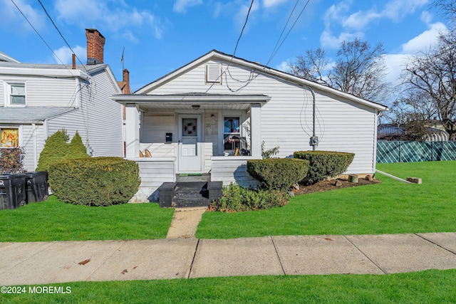 bungalow with covered porch and a front yard