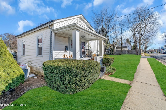 view of side of property featuring a yard and a porch