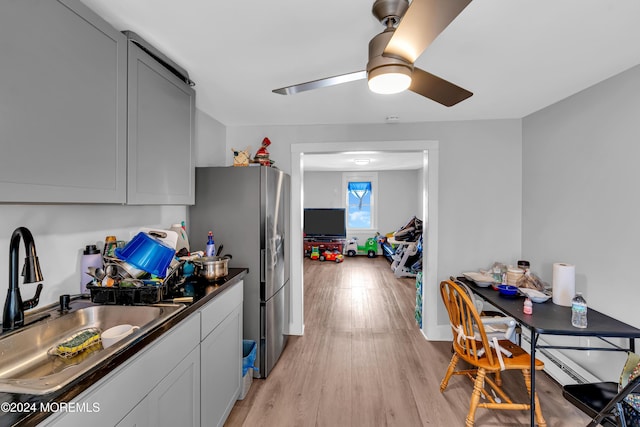 kitchen featuring sink, gray cabinets, stainless steel refrigerator, ceiling fan, and light wood-type flooring