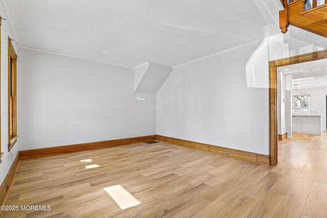 additional living space featuring an inviting chandelier and light hardwood / wood-style flooring